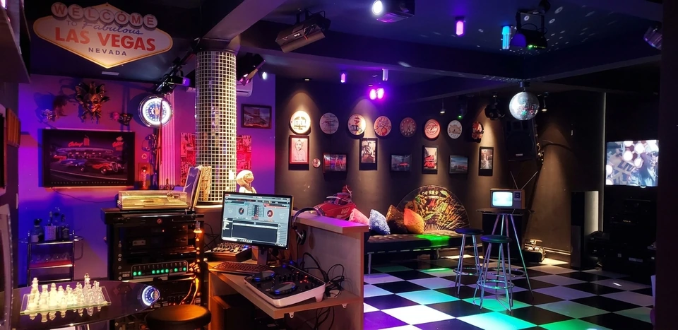 Pub da casa com decoração musical, bar e luzes coloridas
