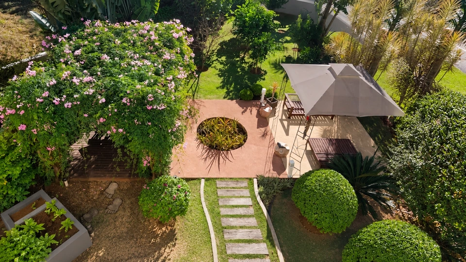 Jardim visto do alto, com árvores e espaço de estar