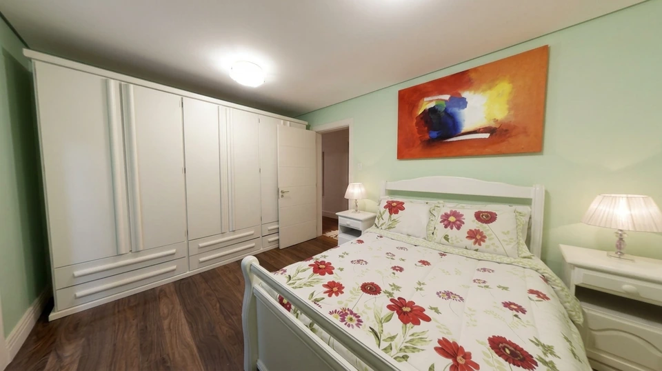 Uma das acomodações da casa, com armários e piso de madeira